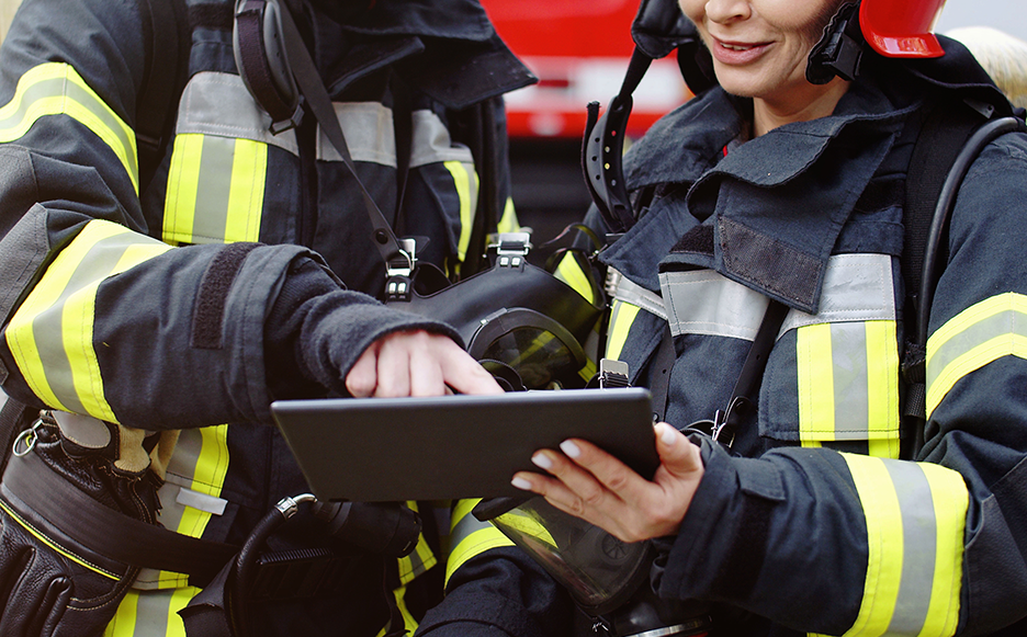 two firefighters look at 3Di Engage fire inspection data on a tablet device